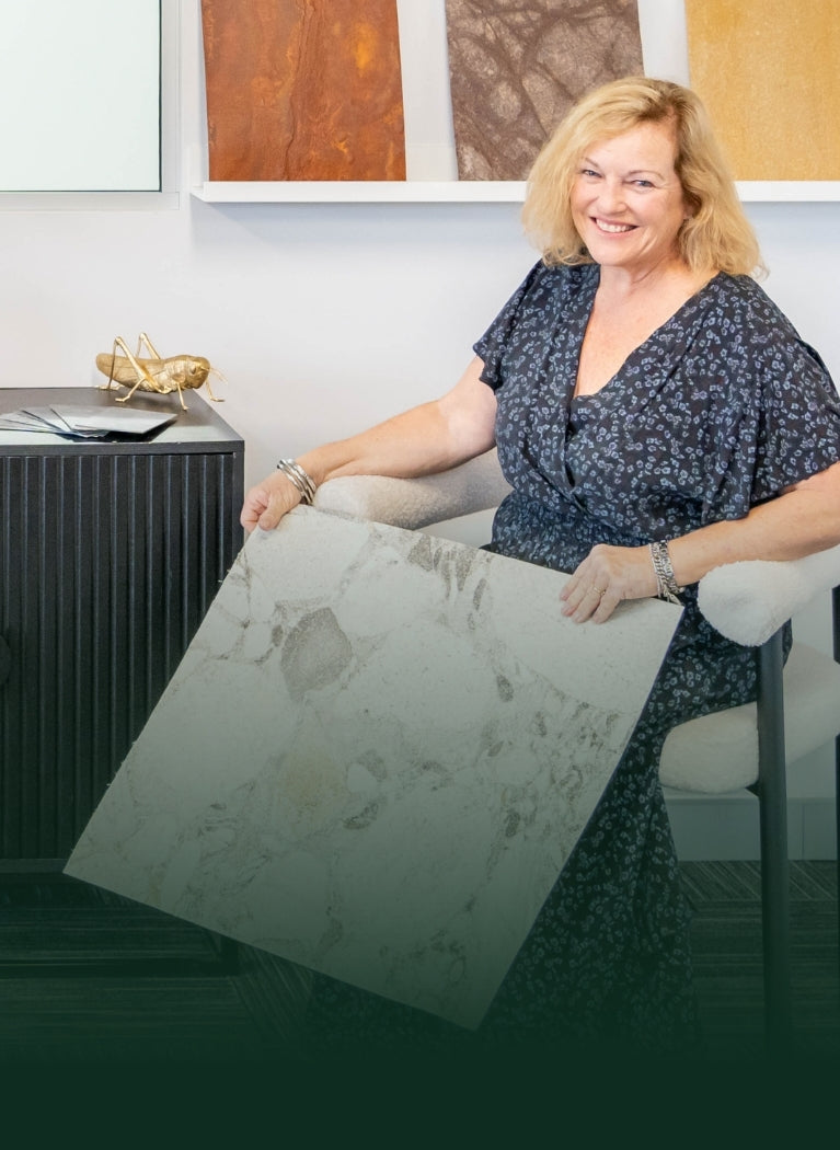 Woman holding a marble sample in a showroom